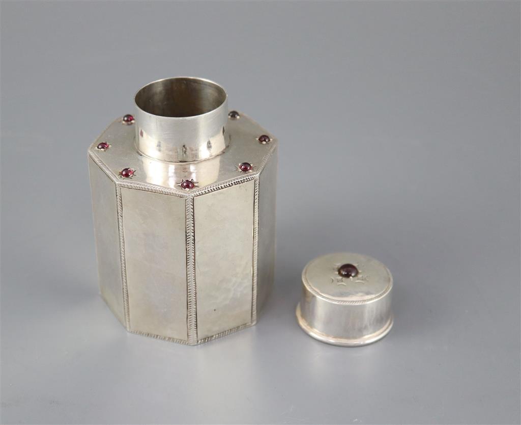 A George V Liberty & Co silver and nine stone cabochon garnet set octagonal tea caddy and cover,